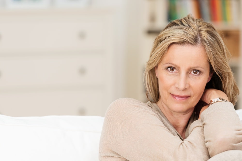 Middle aged woman sitting on a sofa