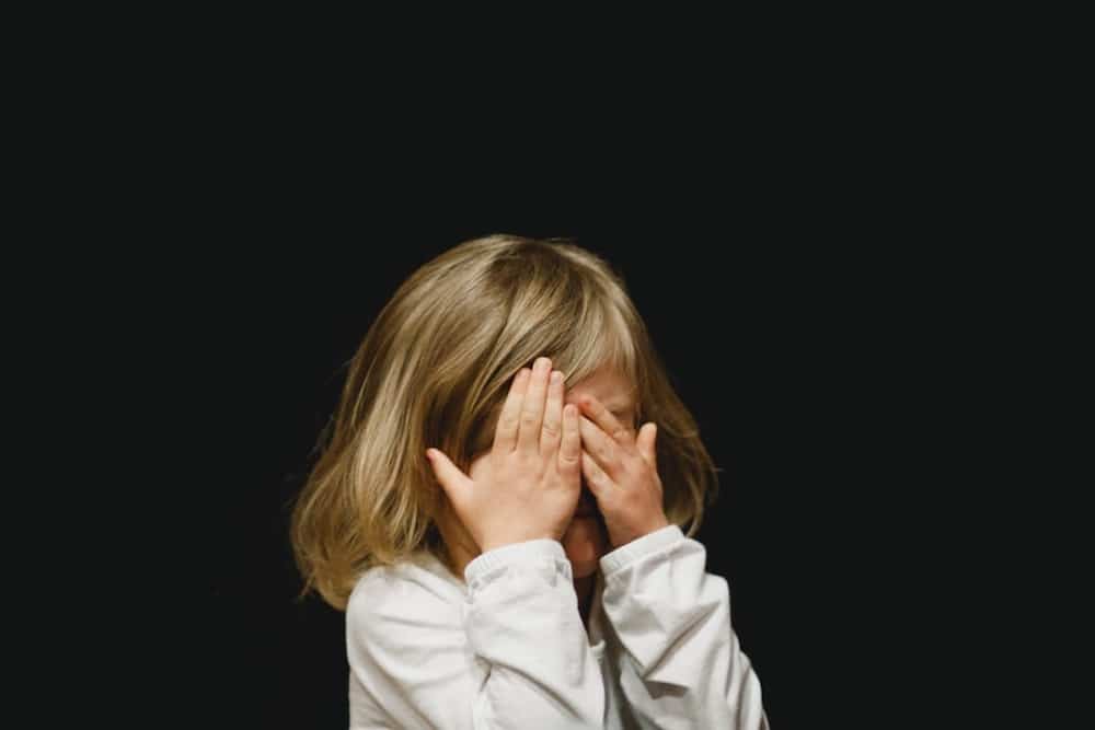 Young child covering their eyes