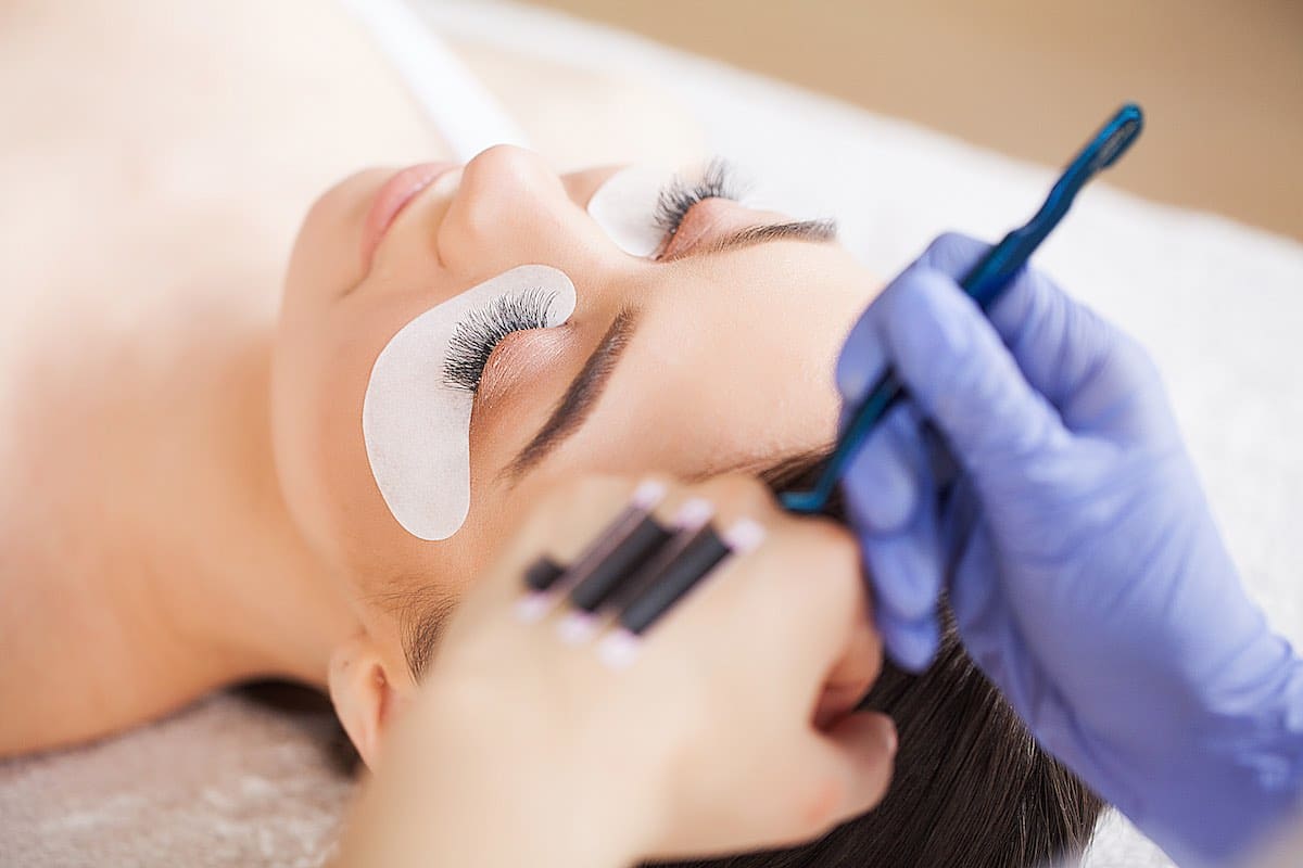 Woman having eyelashes worked on