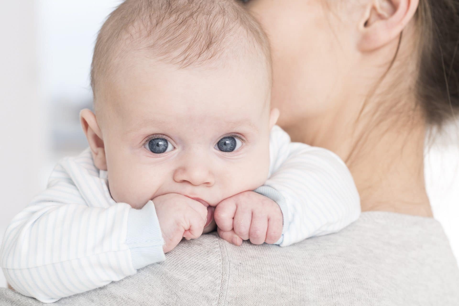 Mother holding her baby on her shoulder