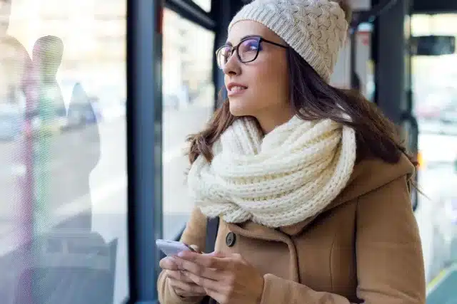 Woman on her phone, looking out a window