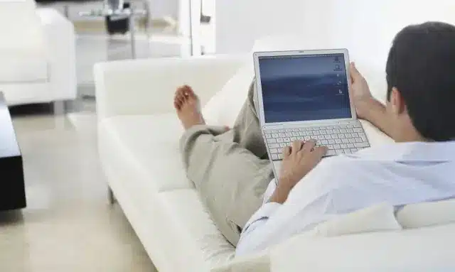 Man using a laptop on his sofa