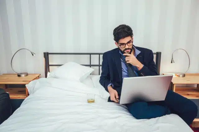 Man working on his laptop on his bed