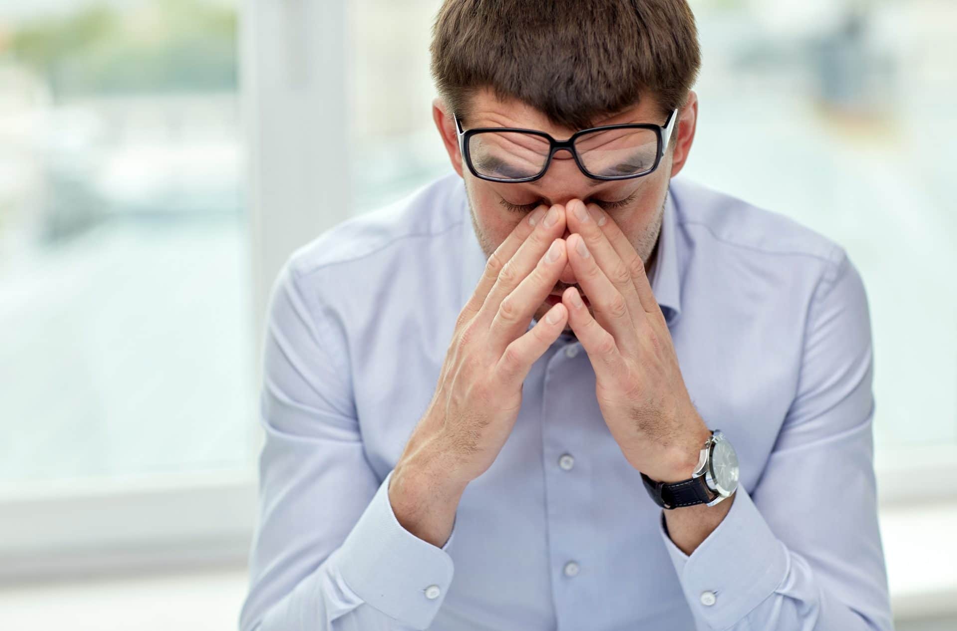 Stressed man rubbing his eyes