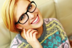 Closeup portrait of a young cheerful woman in glasses