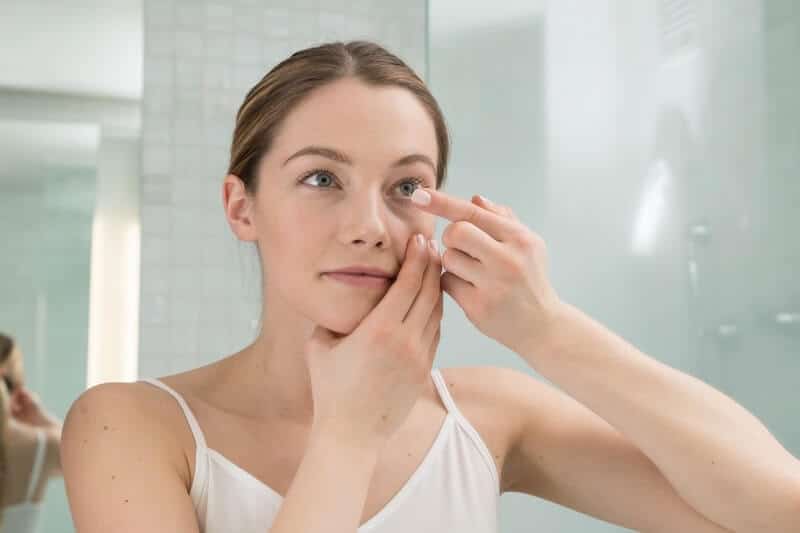 Woman putting in her contact lenses