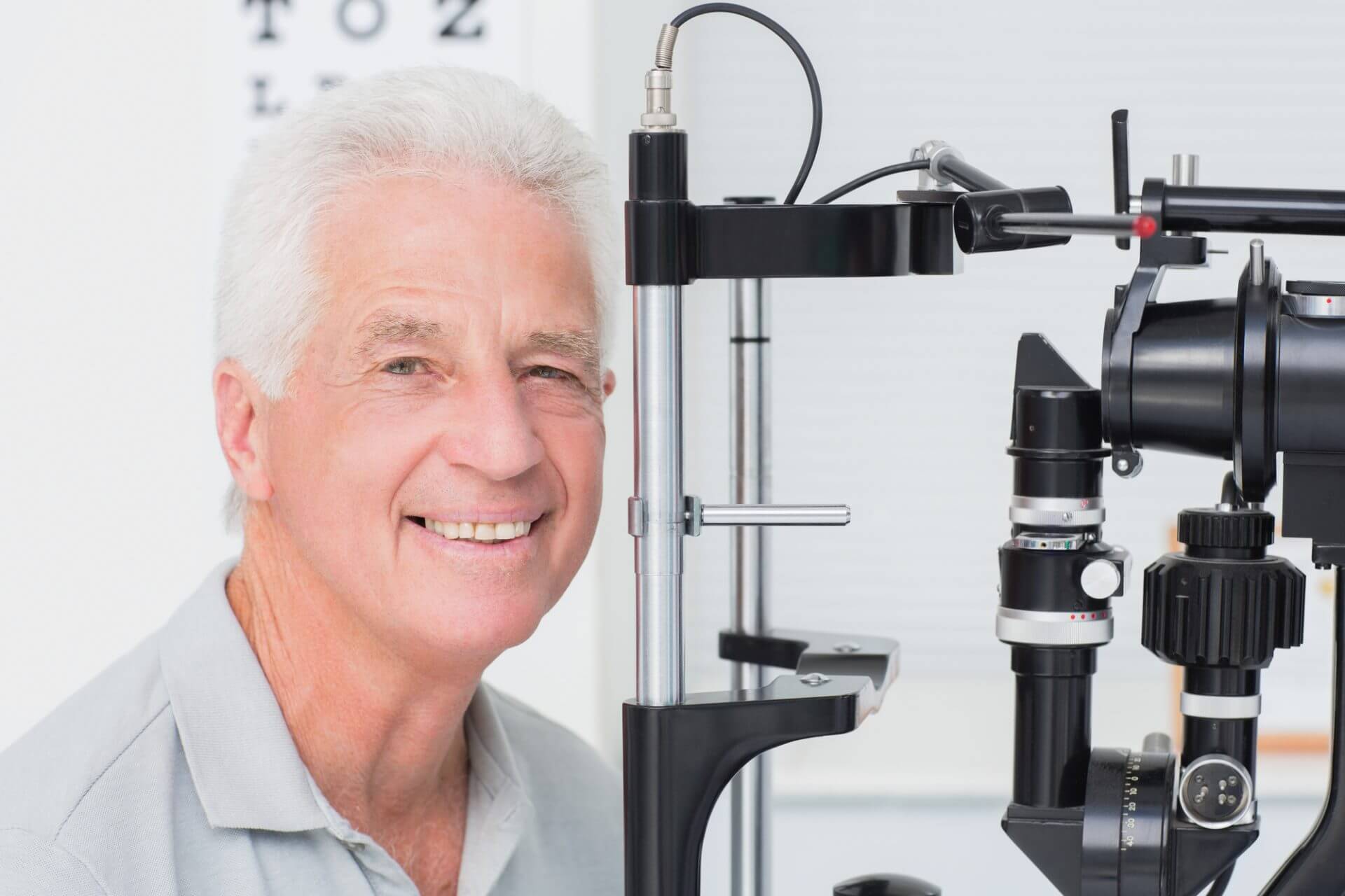 Elderly man smiling while having his eyes tested