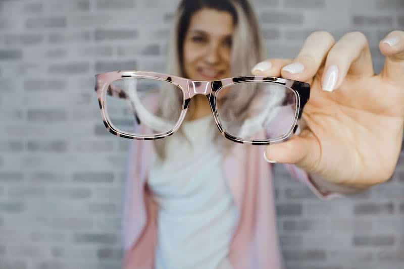 Woman holding her glasses