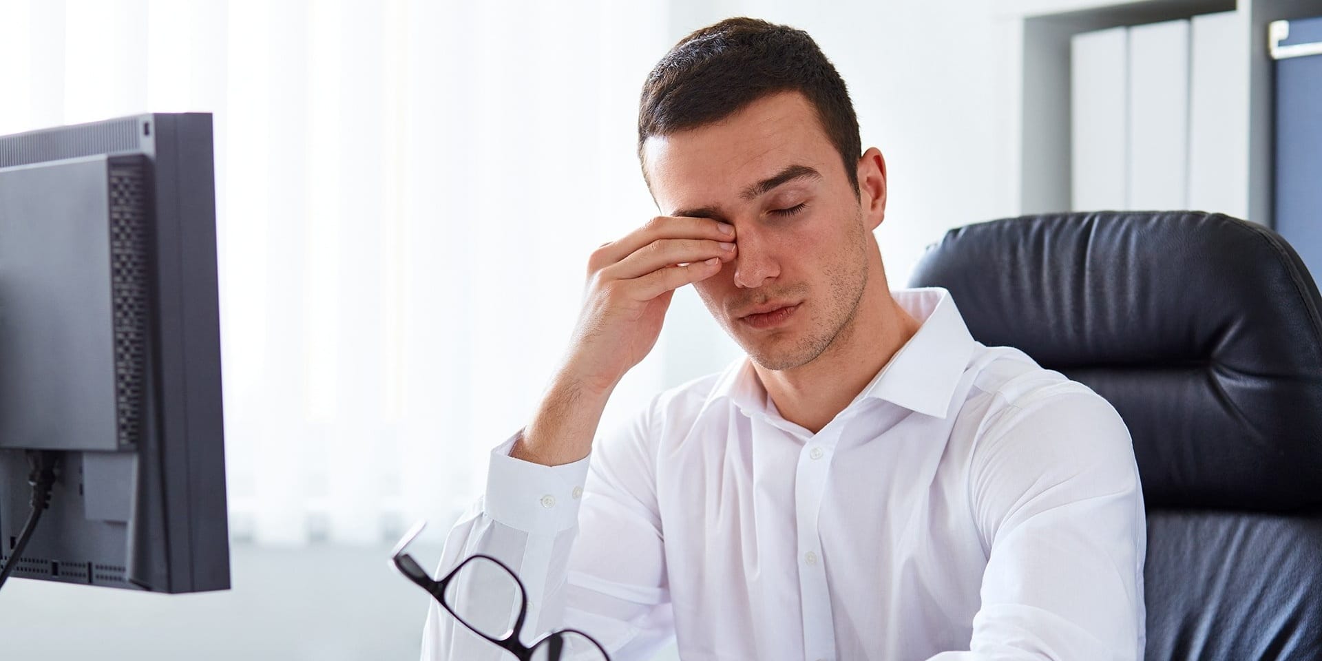 Man holding his glasses and rubbing his eye